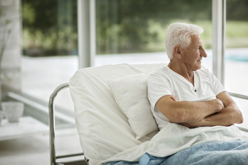 Portrait of senior male patient in a hospital bed.