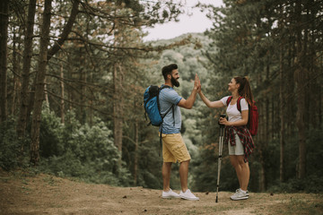 Fototapeta premium Active young hikers taking rest in mountain