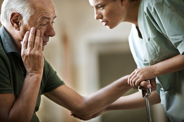 Senior man receiving bad news from a nurse.