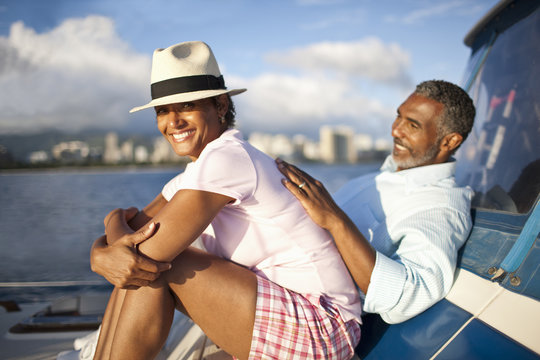 Mature couple lying back, relaxing on boat.