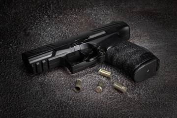 gun with a cartridge on the surface of a rusty metal sheet