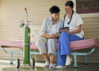 Nurse showing notes to her elderly patient.