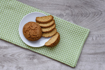 Homemade cookies on a white saucer and green napkins on a wooden background