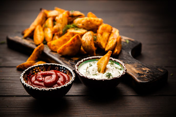 Baked potato fries on wooden table