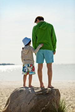 Father and young son have fun at beach.