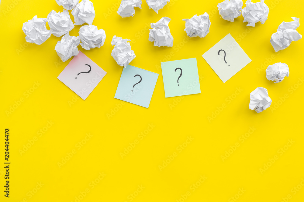 Poster faq concept. question mark on sticky notes near crumpled paper on yellow background top view copy sp