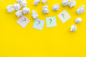 FAQ concept. Question mark on sticky notes near crumpled paper on yellow background top view copy space