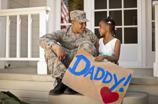 Young girl and her father having a discussion on the front porch of their home.