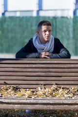 Fototapeta premium Teenager man in relax posture in garden wooden bench