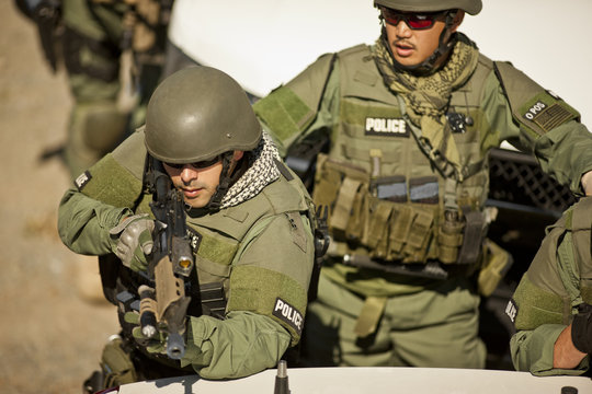 Male police officer aiming a gun toward a target during an exercise at a training facility.