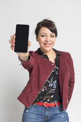 Young woman showing display of mobile cell phone with black screen and smiling on a white background. Focus on hand.