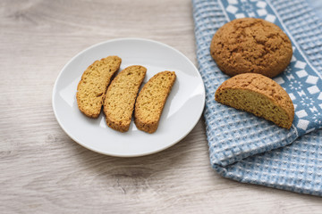 Naklejka premium Homemade cookies on a white saucer and blue napkins on a wooden background
