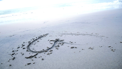 Beautiful heart picture on sand beach background.