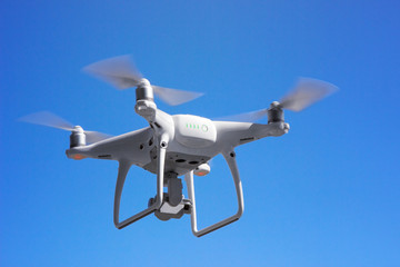 drone, quadrupter copter,  flies against the blue sky, shooting from the air