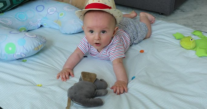 Cute Five Month Old  Baby Boy With His Straw Hat Learning To Crawl And Playing With Toy. Adorable Laughing Child Crawling On A Play Mat - DCi 4K Resolution
