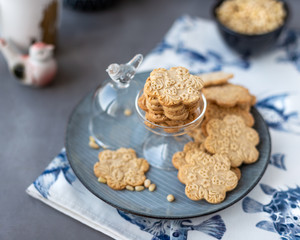 Fototapeta na wymiar On the plate is a curly cookie with decorative patterns made with a wooden rolling pin