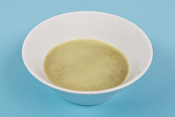 Healthy spinach soup on a blue