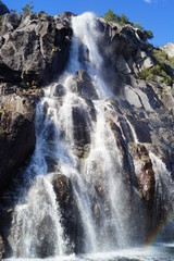 a waterfall with a rainbow and a spray