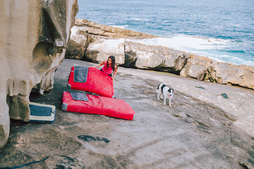 Young climber woman placing safety equipment for bouldering