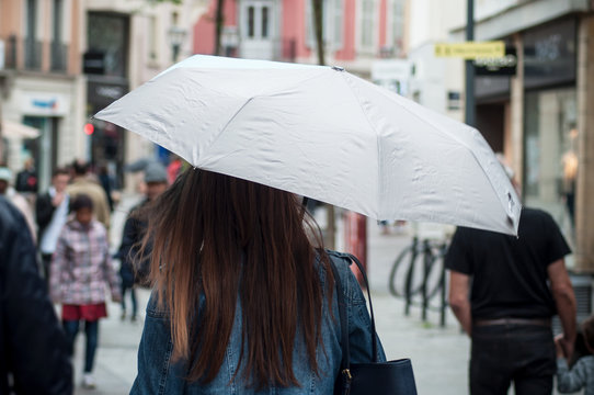 Mulhouse - France - 10 May 2018 - woman walking in the street with umbrella