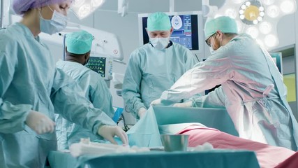 Diverse Team of Professional Surgeons Performing Invasive Surgery on a Patient in the Hospital Operating Room. Surgeonst Use and other Instruments, Anesthesiologist Monitors Vitals. - Powered by Adobe