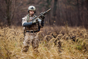 soldier with rifle in full gear. Military man on the background of nature.
