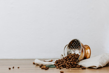 Roasted coffee beans on wooden table with linen napkin