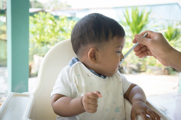 Mom feeding food to baby