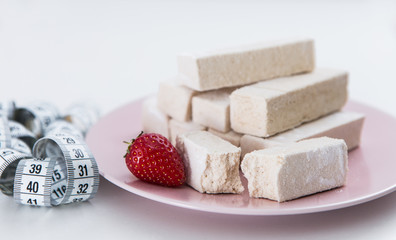 Diet dessert, pastille with measure tape onthe pink plate