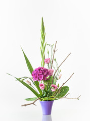 Artistic floral decoration on a table in a ceramic flowerpot isolated on white background.