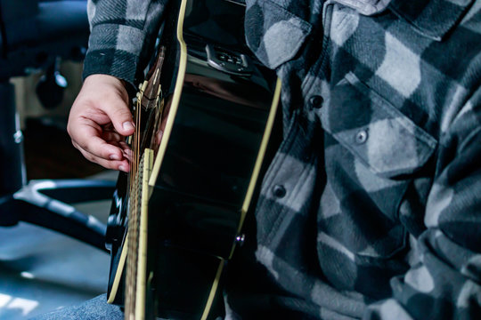 a guitar player wearing plad