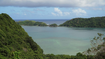 Naklejka premium Seascape tropical island, lagoon, beach and hills.. Tropical landscape sky, clouds and mountains rocks with rainforest. Blue lagoon in the ocean. Travel concept.
