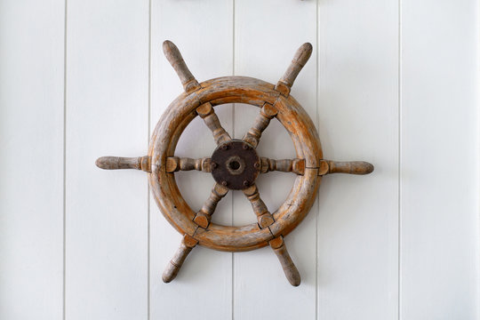 Old Boat Steering Wheel Mounted On The White Wall