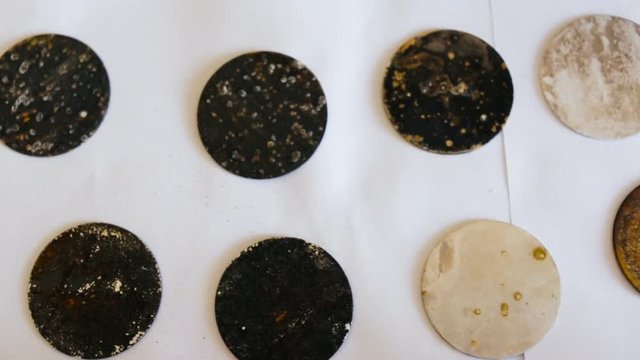 Sample metal round shape with different degrees of corrosion. Top view, camera movement, part scientific experiment, real time, natural light