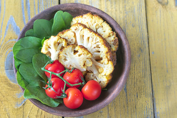 Baked cauliflower with cherry tomatoes and fresh spinach