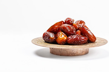 Dried dates on a traditional tray on a white background. Ramadan Kareem