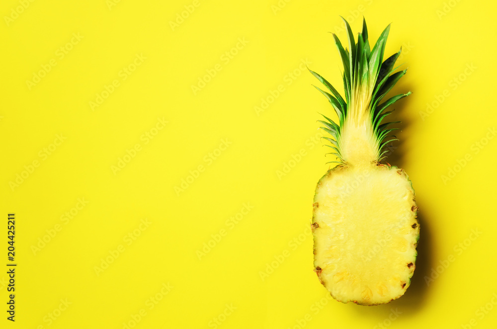 Wall mural half of sliced pineapple on yellow background. top view. copy space. bright pattern for minimal styl