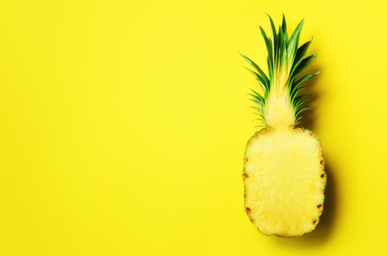 Half of sliced pineapple on yellow background. Top View. Copy Space. Bright pattern for minimal style. Pop art design, creative concept.