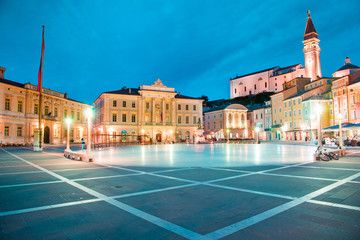 Beautiful city scenery in the central square with the old clock tower in Porec, the tourist center of Croatia, in the light of lanterns.