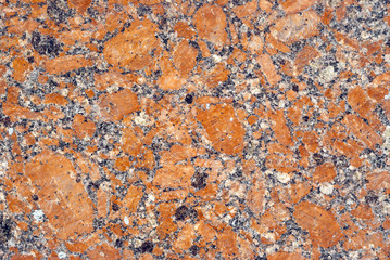 background, texture - variegated surface of polished granite slab with orange impregnations