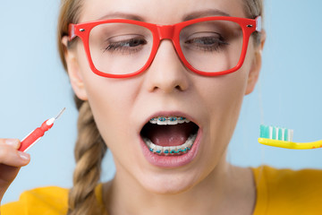 Woman smiling cleaning teeth with braces
