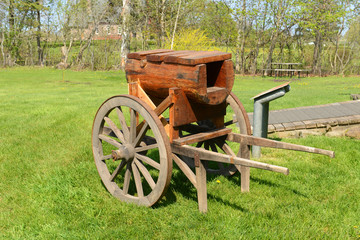 Fototapeta na wymiar A Wood Trolley Cart in front of the Blacksmith shop in Grand-Pré National Historic Site, Wolfville, Nova Scotia, Canada. Grand-Pré area is a center of Acadian settlement from 1682 to 1755.