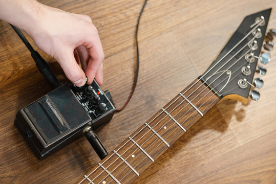 Man adjusting guitar effects pedal