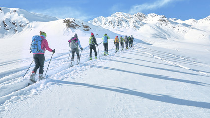 Group of touring skiers whit alpine guide reaching their goal