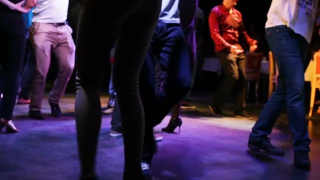 The feet of a boy and a girl dance close up. Beautiful slender thin legs girls in heels chasing after the guy. Party, night, professional dancers of Latin American dance. Close-up, night, indoors, art