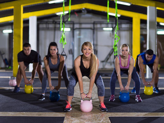 athletes doing exercises with kettlebells