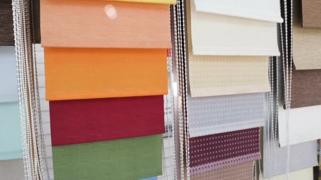 Samples of fabric shutters (roller blinds, blinds, rolstone) window sunscreen system. Outdoors, windy, natural light, real time