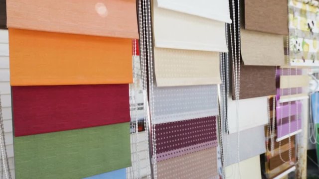 Samples of fabric shutters (roller blinds, blinds, rolstone) &mdash; window sunscreen system. Camera movement from left to right, outside, windy, natural light, real time