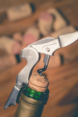 Corkscrew and bottle of wine on the board