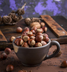 whole hazelnut nutshell in a brown clay cup